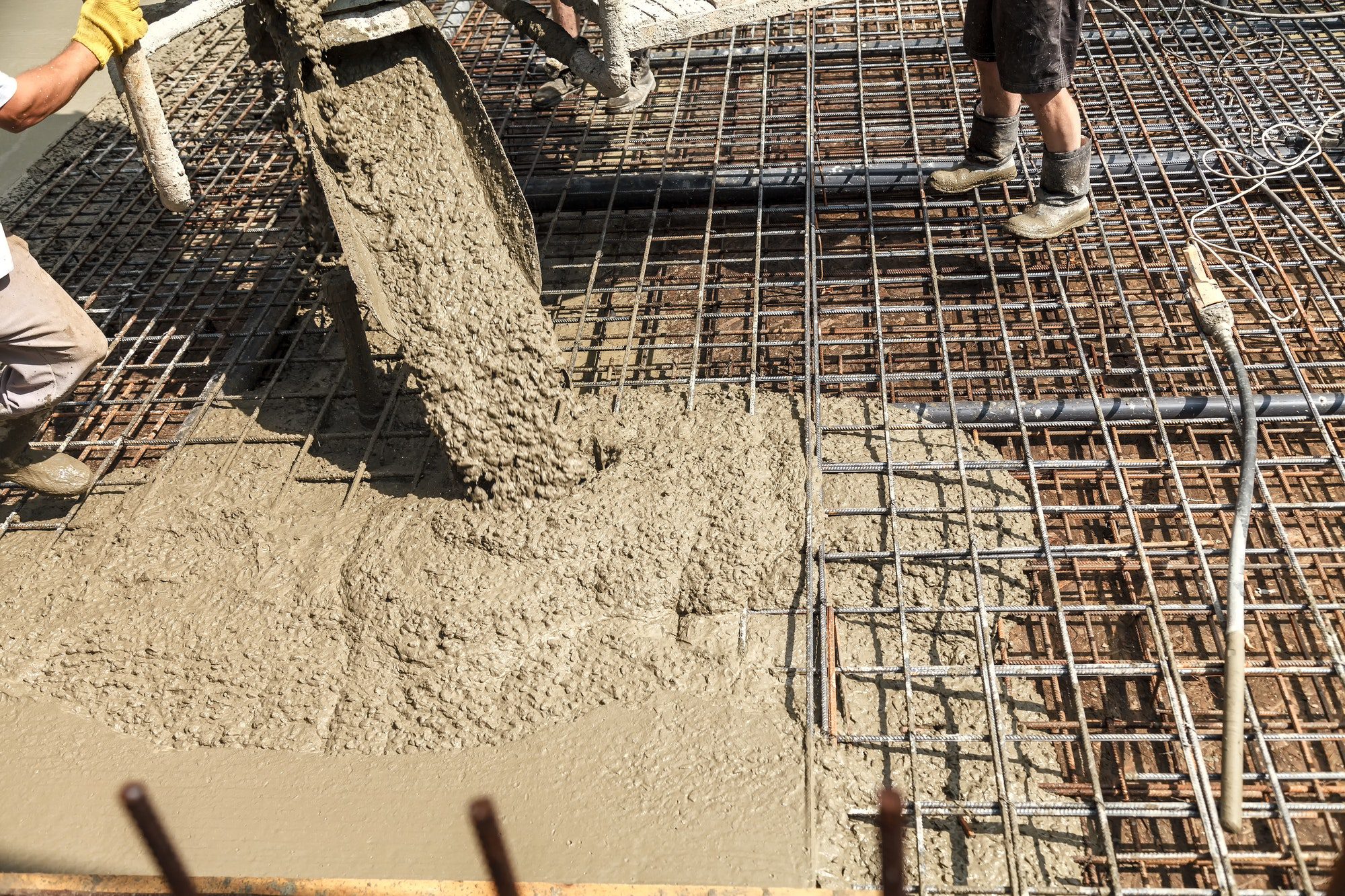 pouring concrete into the construction of the house builders are pouring ready mixed concrete